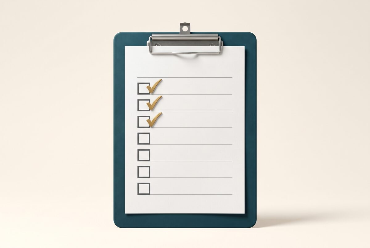 A matte teal clipboard with brushed-gold check marks: action items assembled.